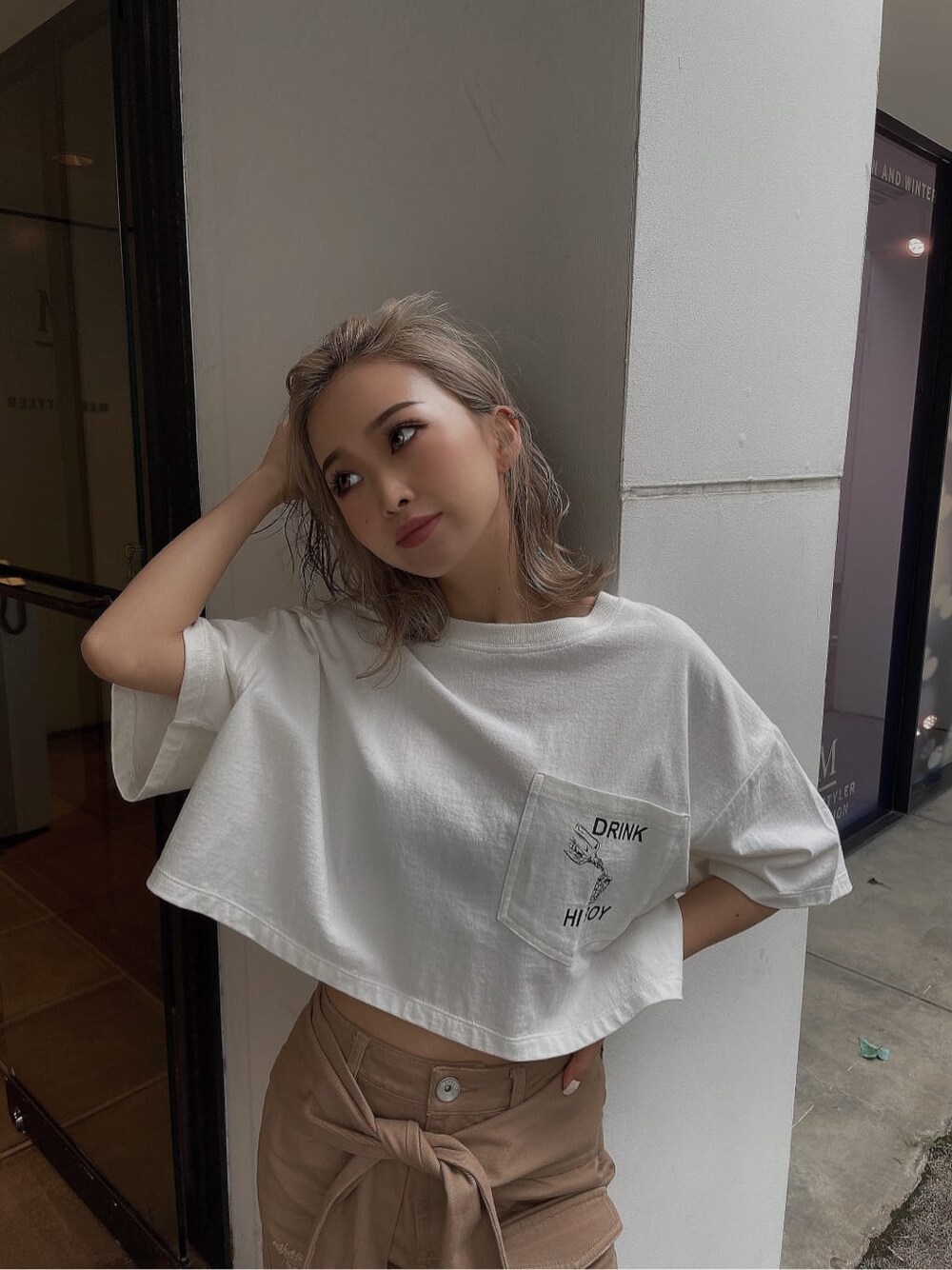 ベージュ系のスカート、ホワイト系のTシャツ/カットソーを着用したレディースの夏コーディネートの2枚目の写真