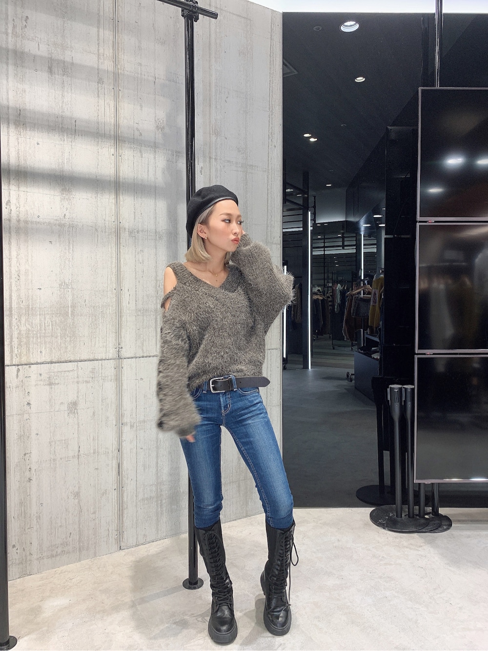 グレー系のニット/セーター、ブルー系のデニムパンツ、ブラック系のブーツを着用したレディースの秋コーディネートの3枚目の写真