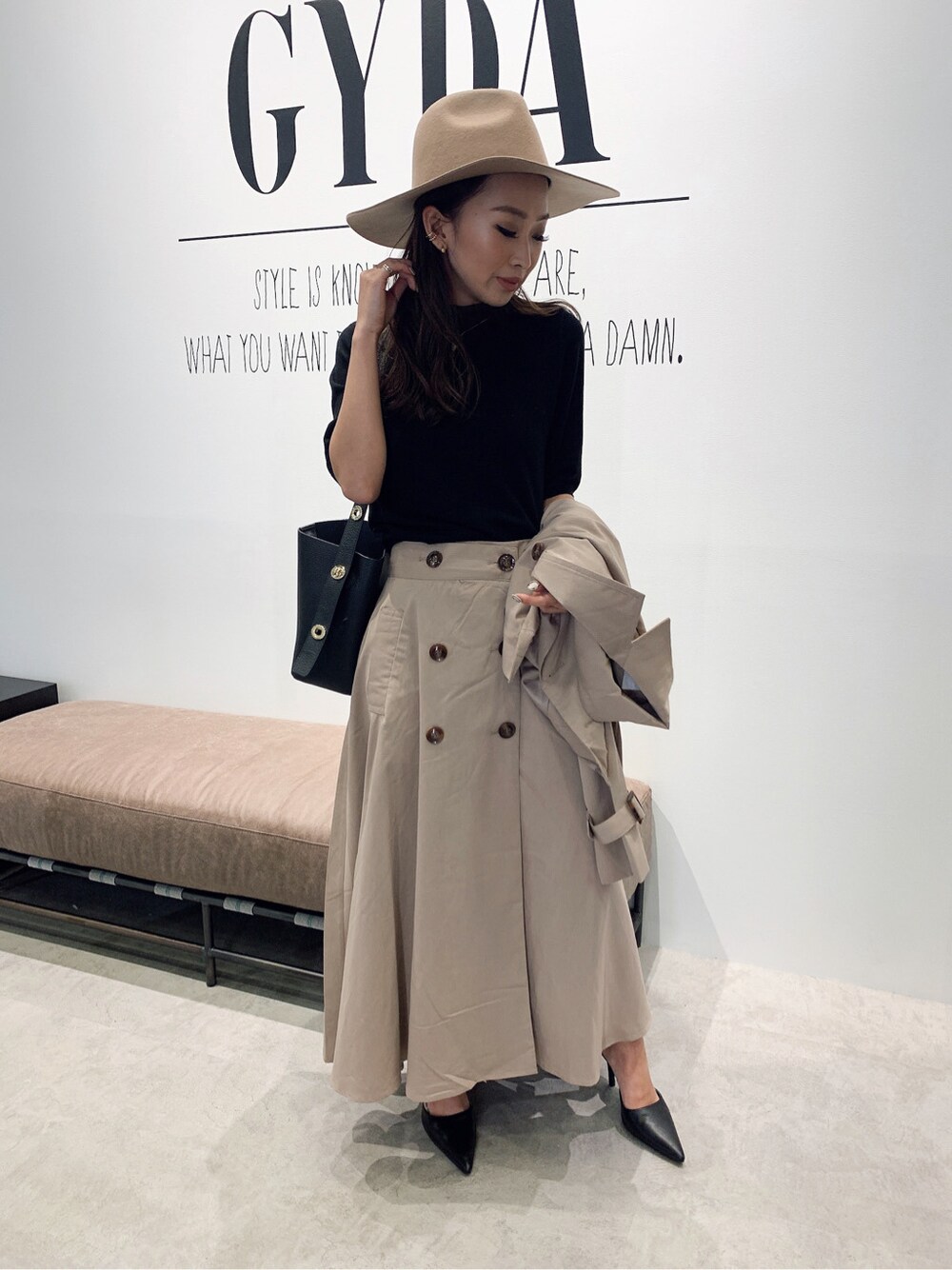 ブラック系のニット/セーター、ベージュ系のトレンチコート、ブラック系のパンプスを着用したレディースの夏コーディネートの3枚目の写真