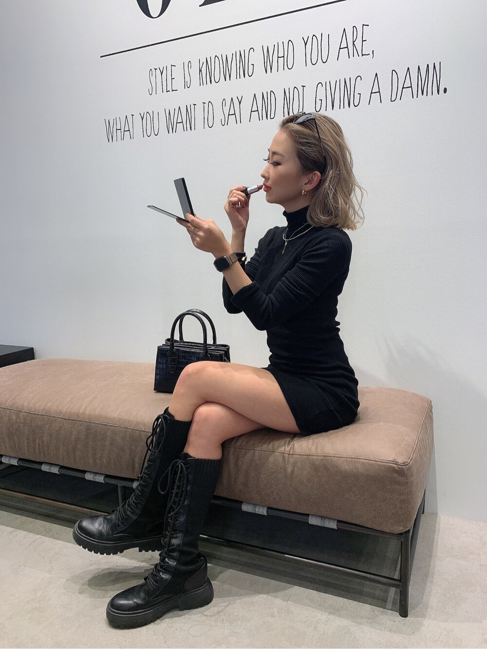 ブラック系のワンピース、ブラック系のショルダーバッグを着用したレディースの冬コーディネートの2枚目の写真