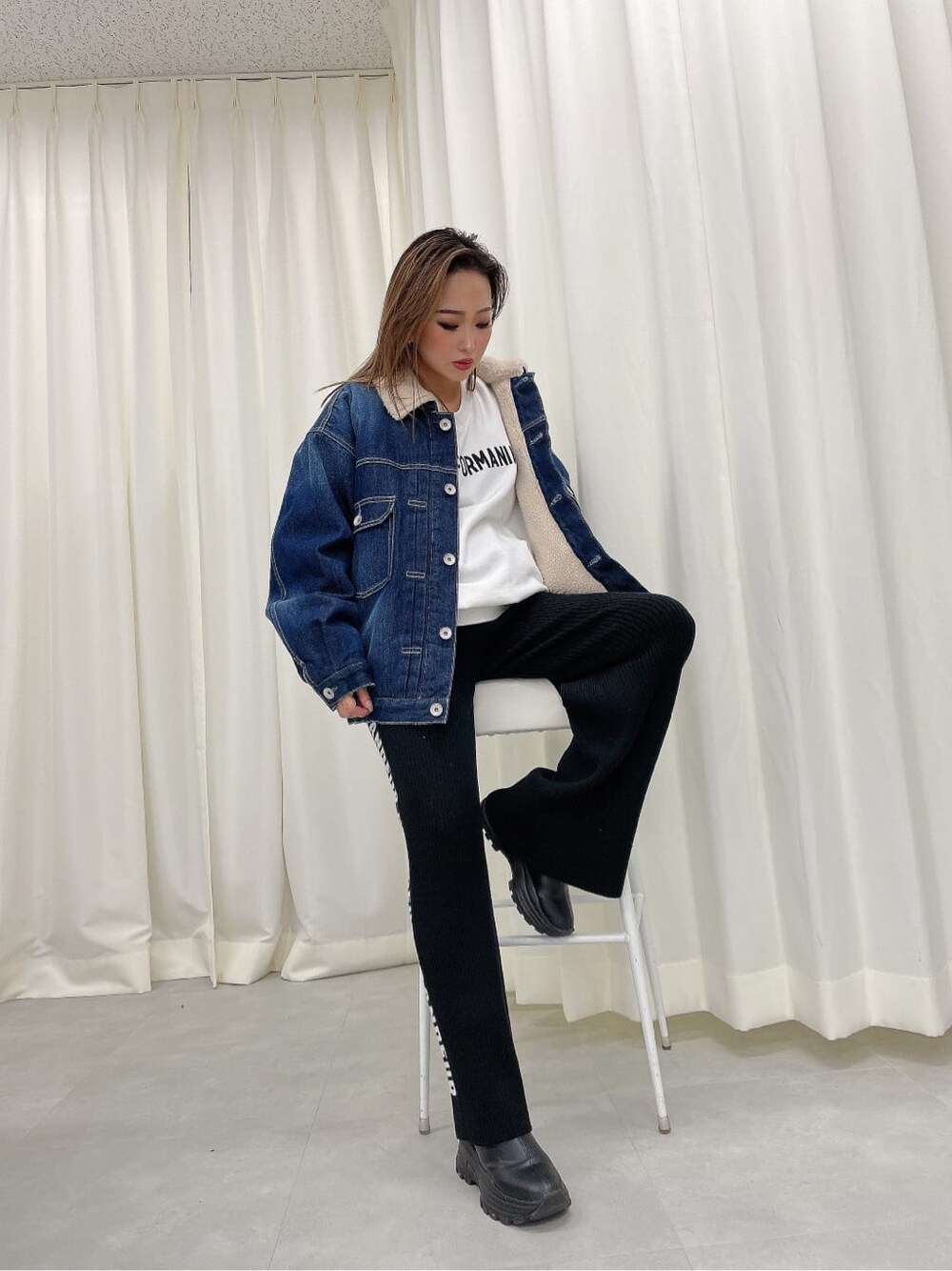 ホワイト系のスウェット、ブルー系のデニムジャケット、ブラック系のその他パンツを着用したレディースの秋コーディネートの2枚目の写真