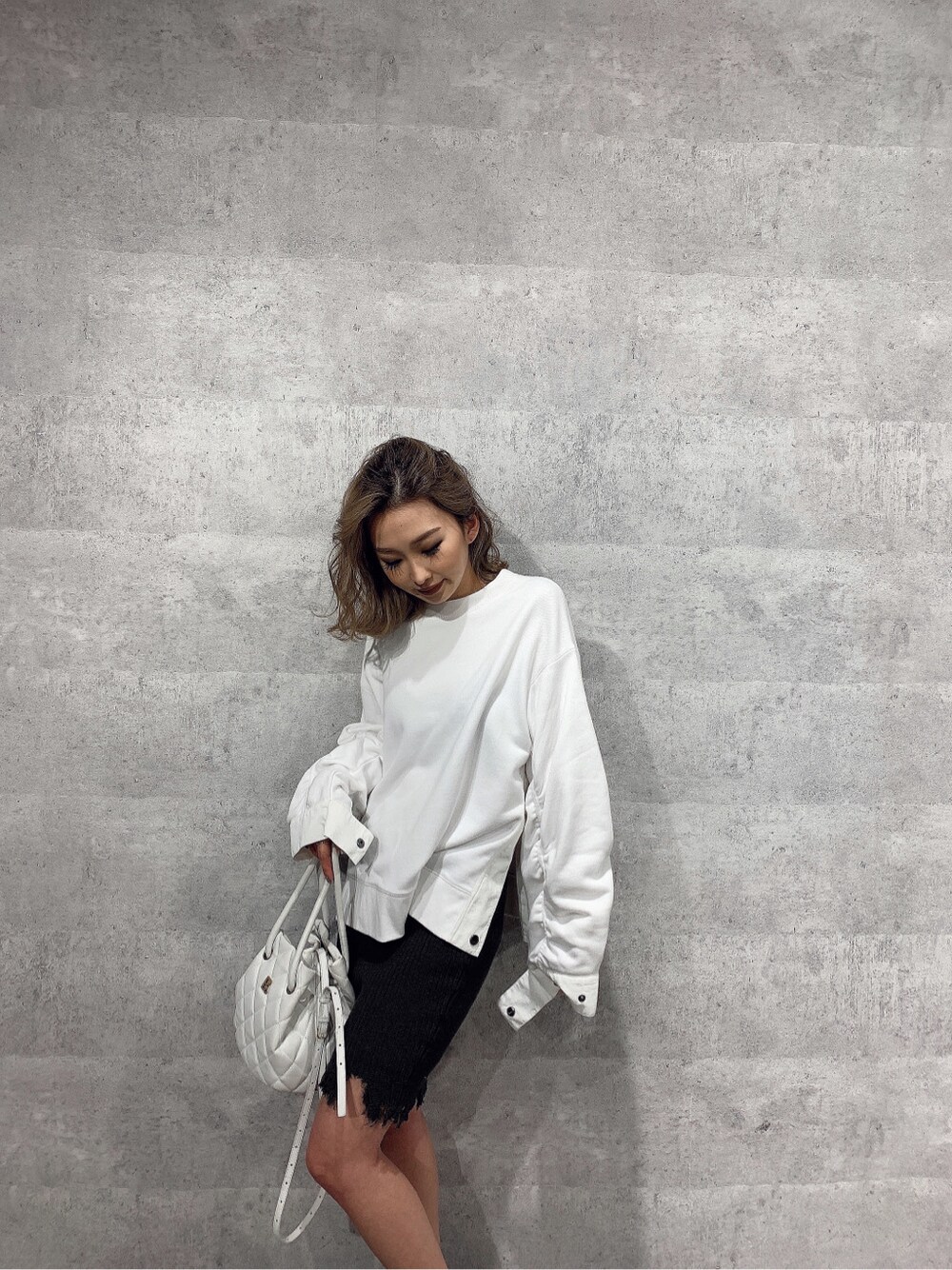 ホワイト系のスウェット、グレー系のスカートを着用したレディースの冬コーディネートの3枚目の写真