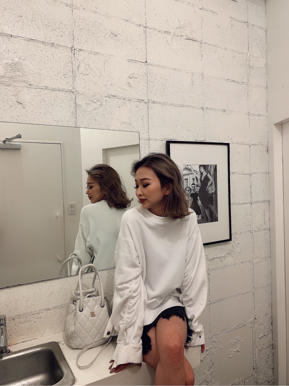 ホワイト系のスウェット、グレー系のスカートを着用したレディースの冬コーディネートの2枚目の写真