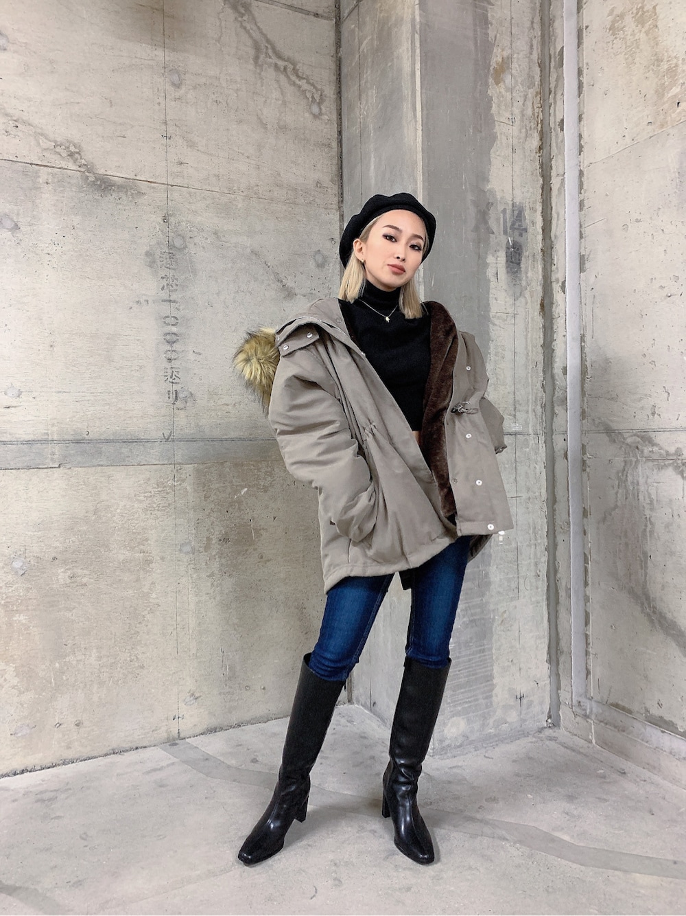 ベージュ系のミリタリージャケット、ブルー系のデニムパンツ、ブラック系のブーツを着用したレディースの秋コーディネートの2枚目の写真