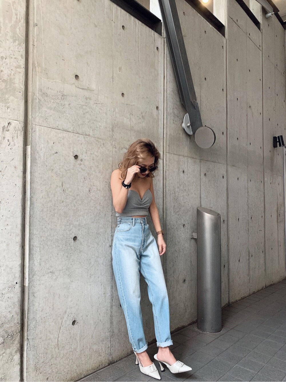 ホワイト系のパンプス、ブルー系のデニムパンツを着用したレディースの冬コーディネートの2枚目の写真