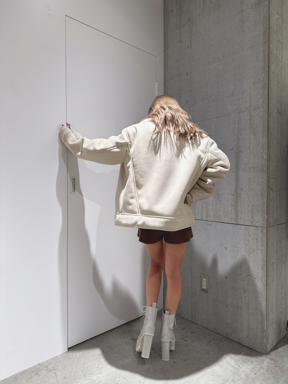 ブラウン系のつなぎ/オールインワン、ホワイト系のムートンコート、ホワイト系のブーツを着用したレディースの秋コーディネートの4枚目の写真