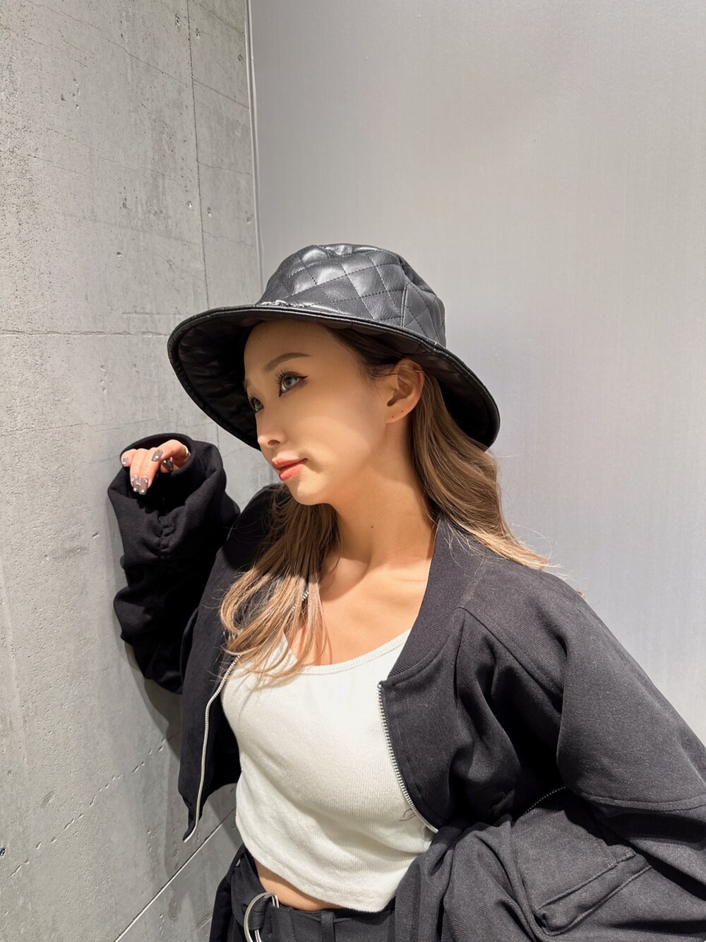 ブラック系のブルゾン、ブラック系のスウェットパンツ、ブラック系のハンドバッグを着用したレディースの冬コーディネートの3枚目の写真