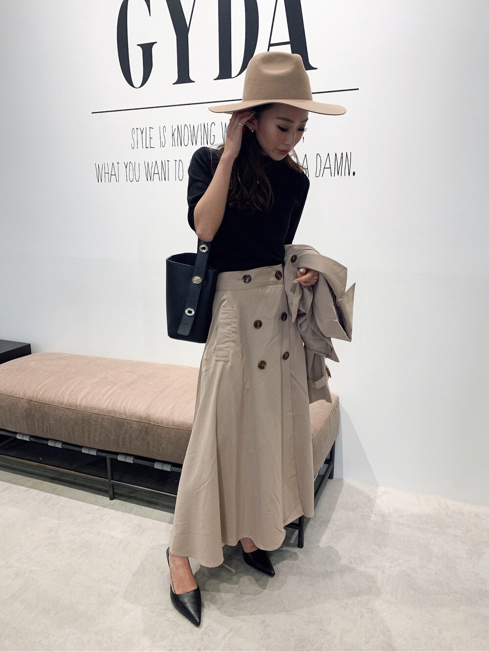 ブラック系のニット/セーター、ベージュ系のトレンチコート、ブラック系のパンプスを着用したレディースの夏コーディネートの2枚目の写真