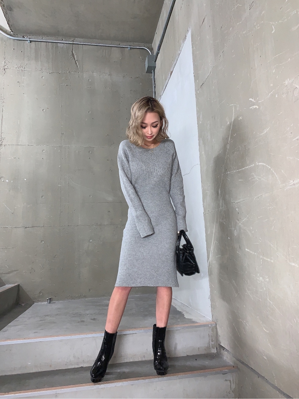 ブラック系のブーツ、グレー系のワンピース、ブラック系のショルダーバッグを着用したレディースの冬コーディネートの4枚目の写真