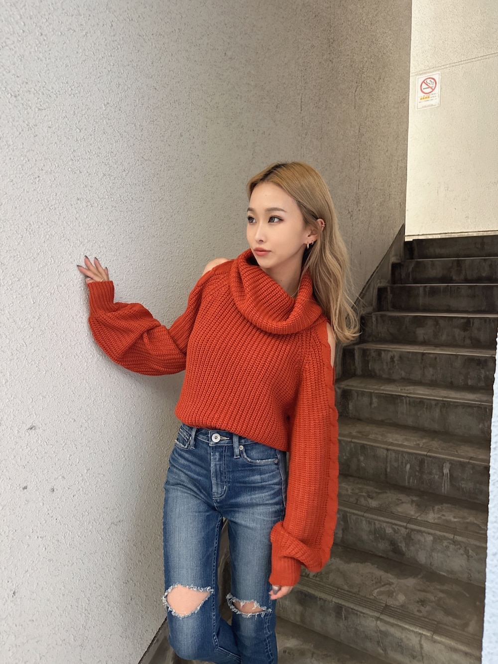 オレンジ系のニット/セーター、ブルー系のデニムパンツ、ブラック系のパンプスを着用したレディースの秋コーディネートの3枚目の写真