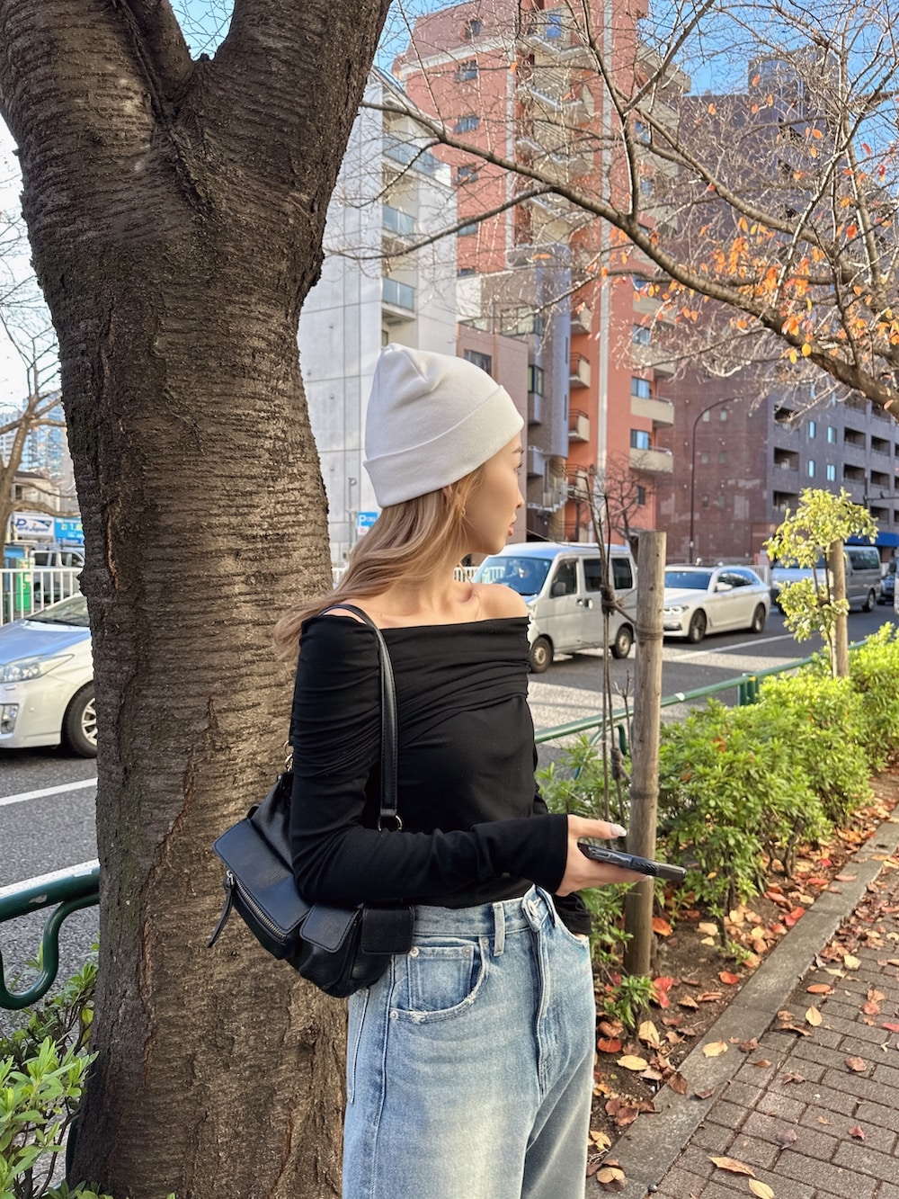 ブラック系のTシャツ/カットソー、ブルー系のデニムパンツ、ホワイト系のニットキャップ/ビーニーを着用したレディースの冬コーディネートの2枚目の写真