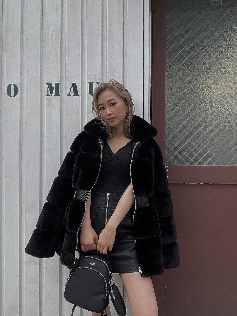 ブラック系のその他アウター、ブラック系のスカート、ブラック系のバックパック/リュックを着用したレディースの冬コーディネートの3枚目の写真