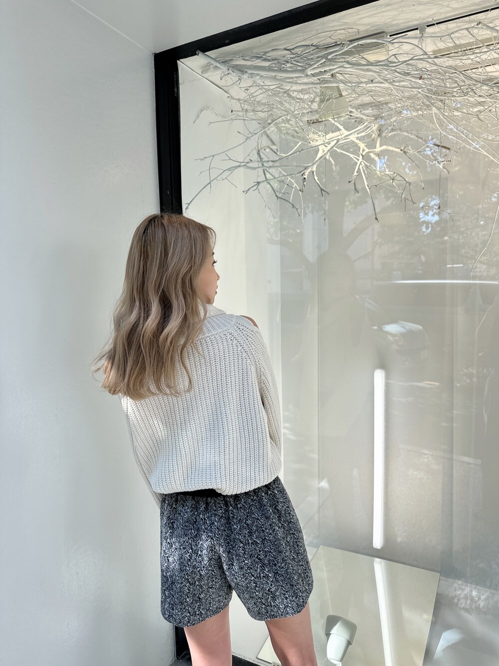 ホワイト系のニット/セーター、ブラック系のその他パンツ、ブラック系のブーツを着用したレディースの秋コーディネートの4枚目の写真