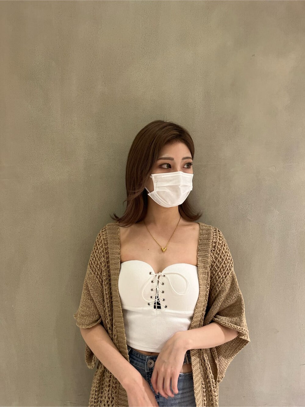 ホワイト系のパンプス、ホワイト系のキャミソール、ブルー系のデニムパンツを着用したレディースの夏コーディネートの4枚目の写真