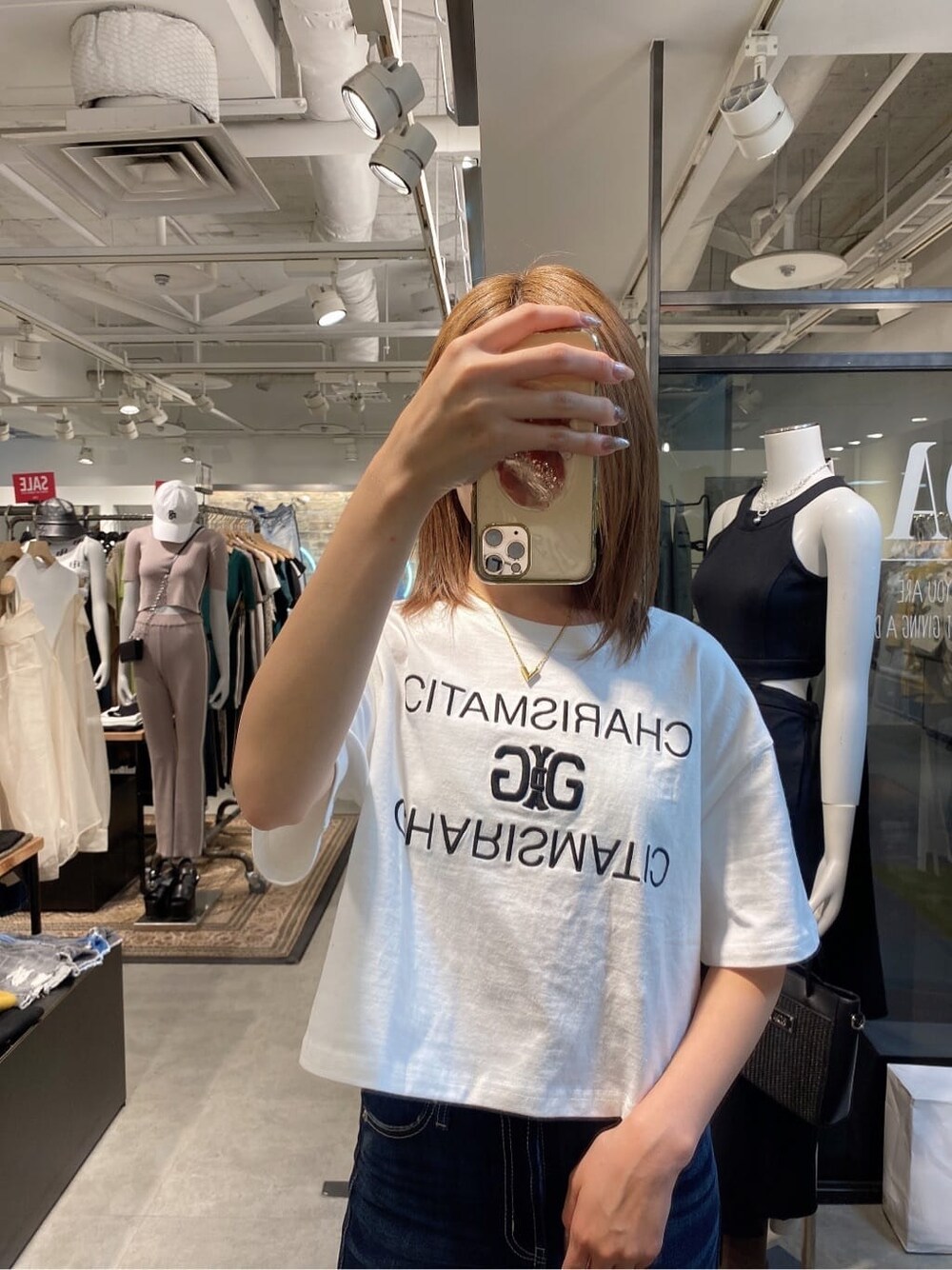 ブルー系のデニムパンツ、ホワイト系のTシャツ/カットソー、ホワイト系のパンプスを着用したレディースの夏コーディネートの3枚目の写真