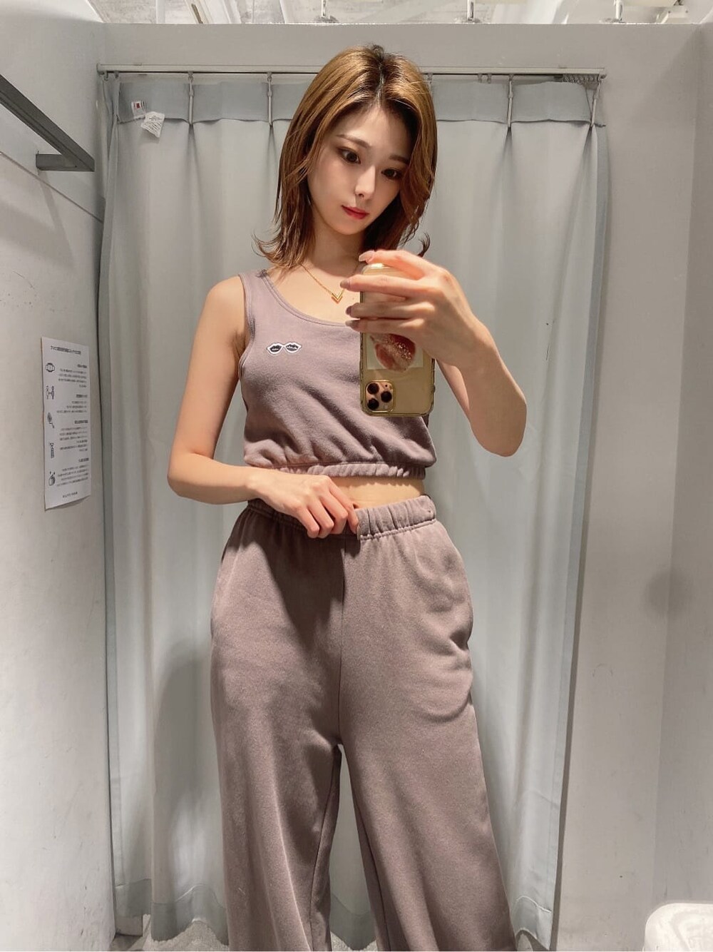ホワイト系のパンプス、ベージュ系のスウェットパンツ、ベージュ系のタンクトップを着用したレディースの夏コーディネートの2枚目の写真
