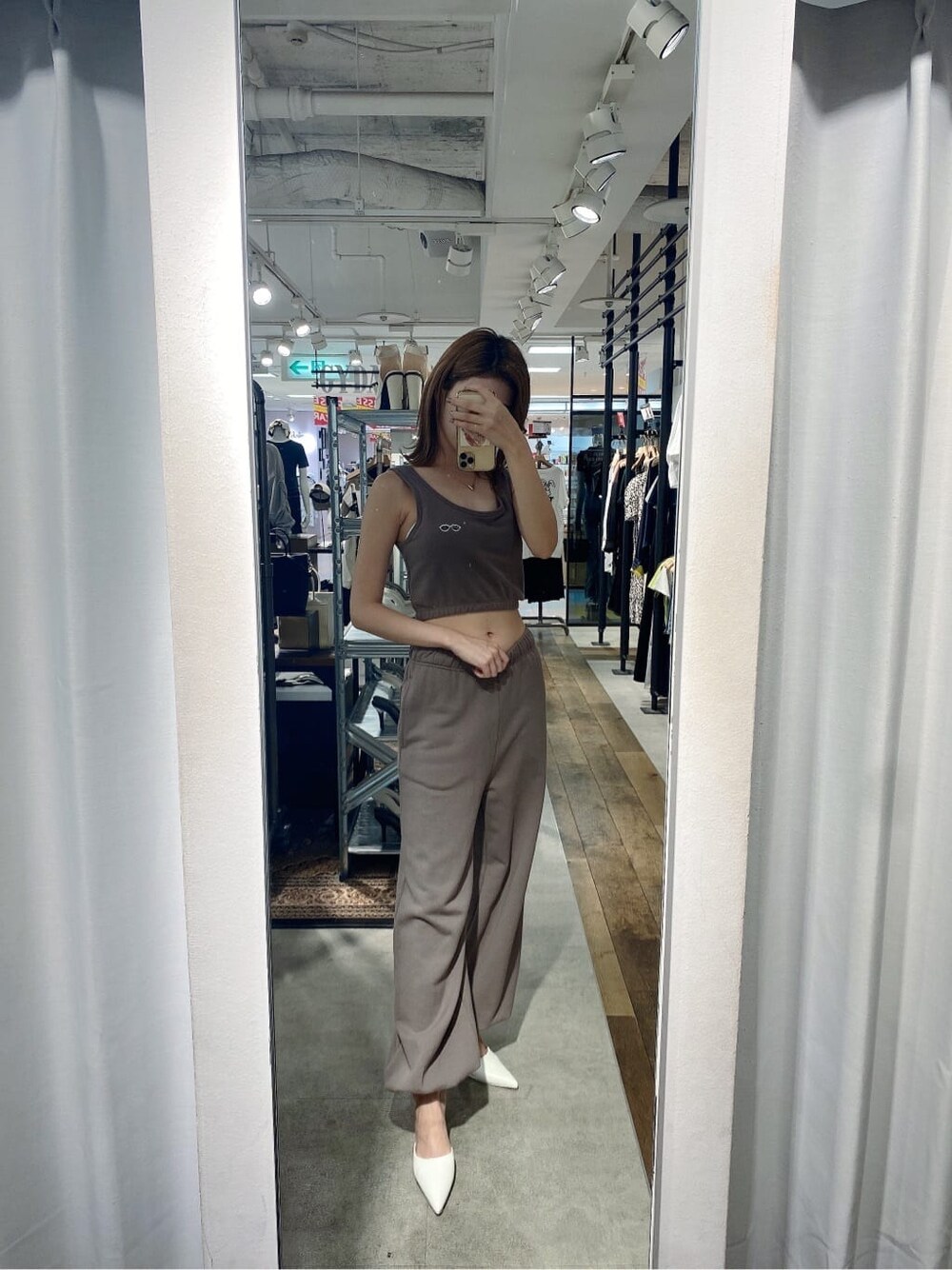 ホワイト系のパンプス、ベージュ系のスウェットパンツ、ベージュ系のタンクトップを着用したレディースの夏コーディネートの6枚目の写真