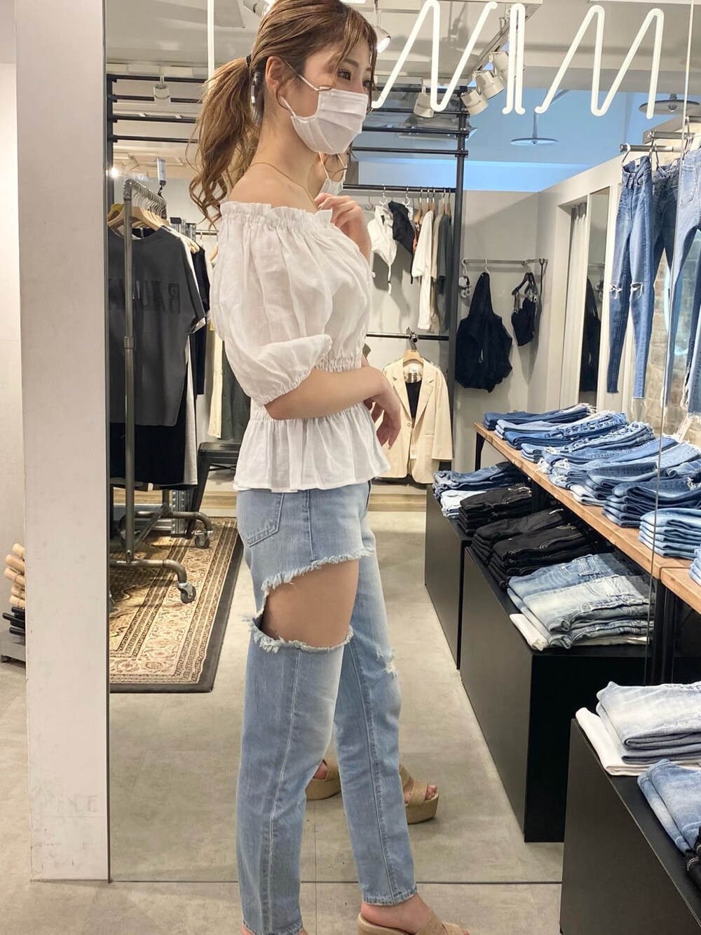 ベージュ系のハンドバッグ、ホワイト系のシャツ/ブラウス、ホワイト系のサンダルを着用したレディースの春コーディネートの3枚目の写真