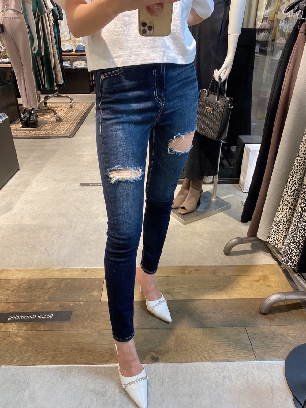 ブルー系のデニムパンツ、ホワイト系のTシャツ/カットソー、ホワイト系のパンプスを着用したレディースの夏コーディネートの5枚目の写真