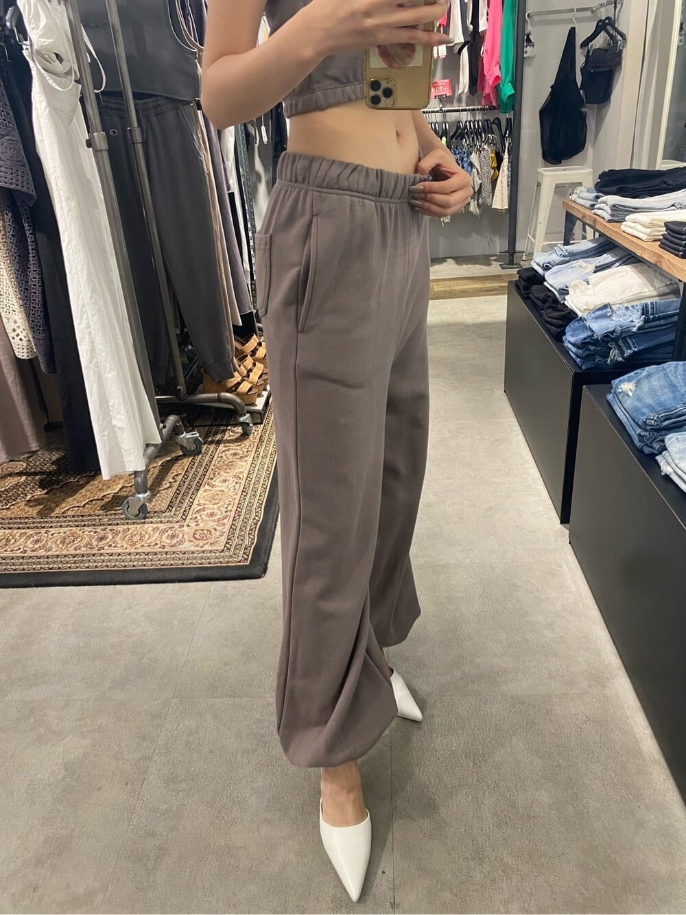 ホワイト系のパンプス、ベージュ系のスウェットパンツ、ベージュ系のタンクトップを着用したレディースの夏コーディネートの7枚目の写真