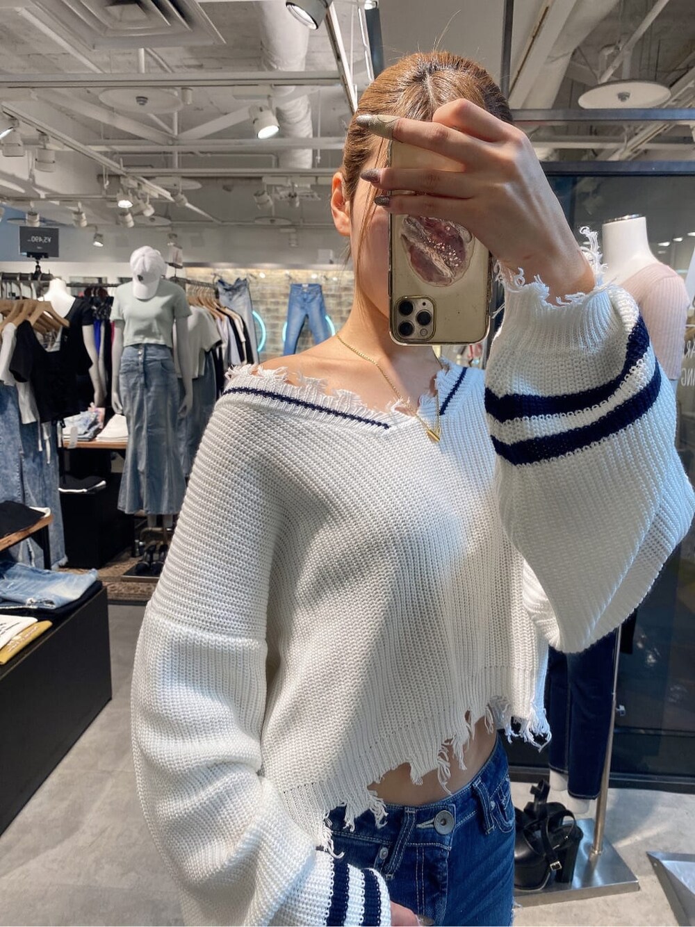 ブラック系のパンプス、ホワイト系のニット/セーター、ブルー系のデニムパンツを着用したレディースの夏コーディネートの6枚目の写真