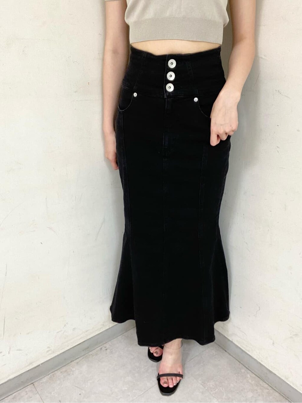 ブラック系のサンダル、ベージュ系のニット/セーター、ブラック系のデニムスカートを着用したレディースの夏コーディネートの7枚目の写真