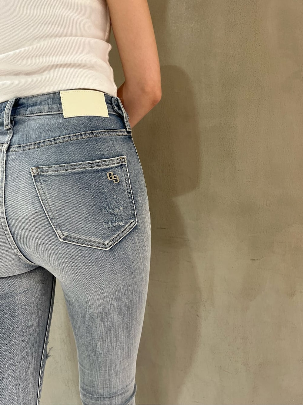 ホワイト系のパンプス、ホワイト系のキャミソール、ブルー系のデニムパンツを着用したレディースの夏コーディネートの8枚目の写真