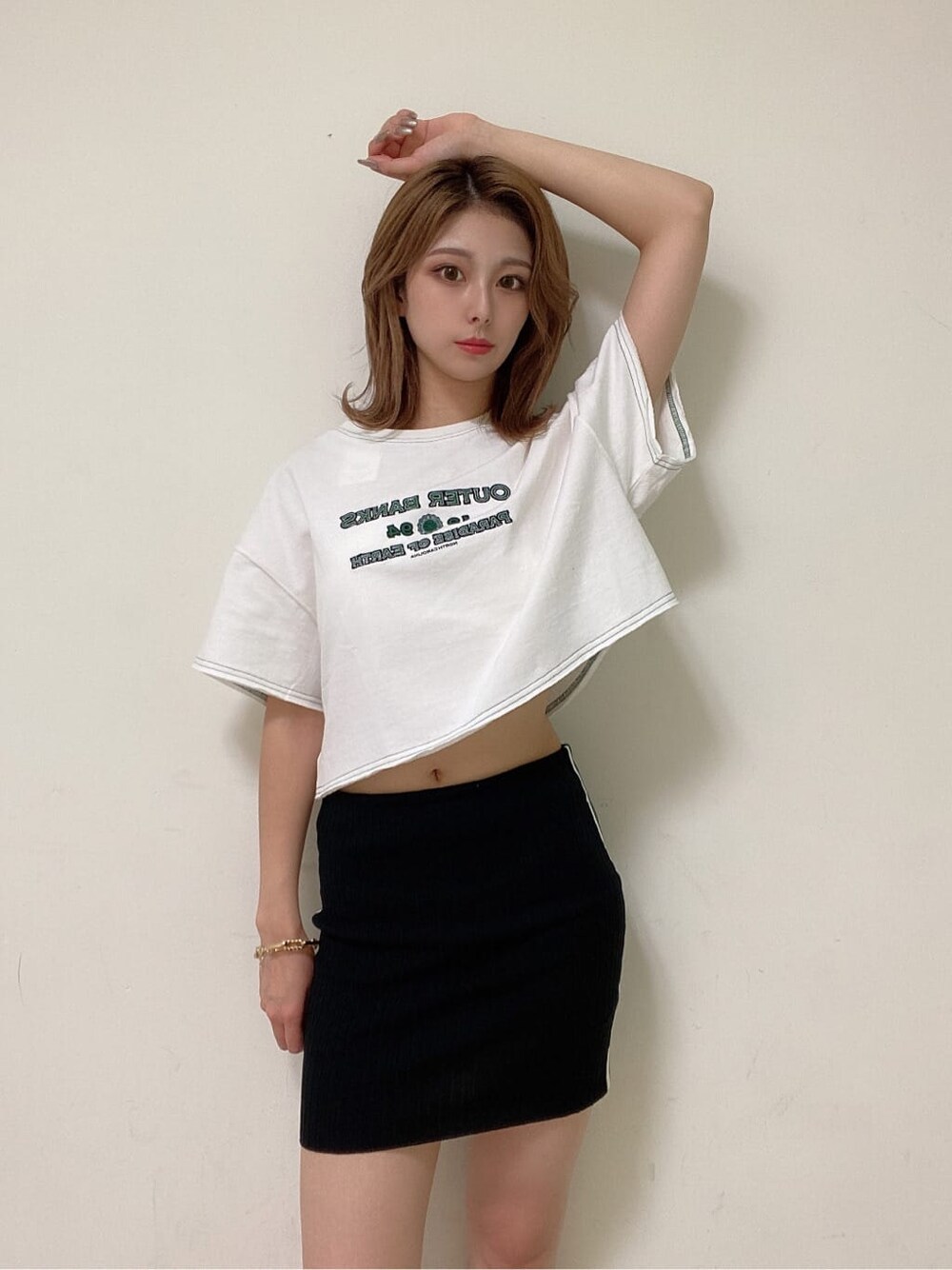 ブラック系のスカート、ブラック系のサンダル、ホワイト系のTシャツ/カットソーを着用したレディースの夏コーディネートの4枚目の写真