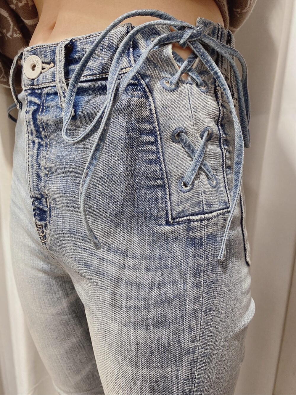 ホワイト系のパンプス、ベージュ系のニット/セーター、ブルー系のデニムパンツを着用したレディースの冬コーディネートの3枚目の写真