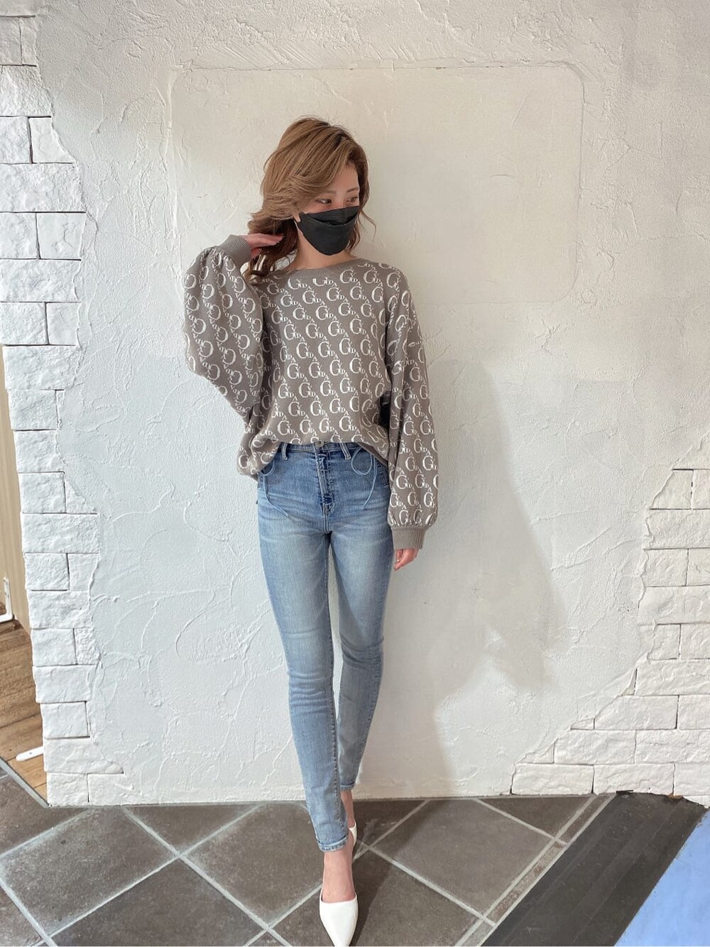 ホワイト系のパンプス、ベージュ系のニット/セーター、ブルー系のデニムパンツを着用したレディースの冬コーディネートの2枚目の写真