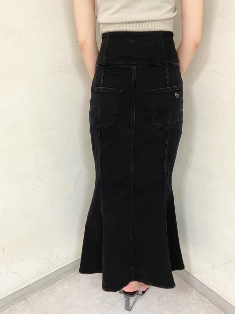 ブラック系のサンダル、ベージュ系のニット/セーター、ブラック系のデニムスカートを着用したレディースの夏コーディネートの9枚目の写真