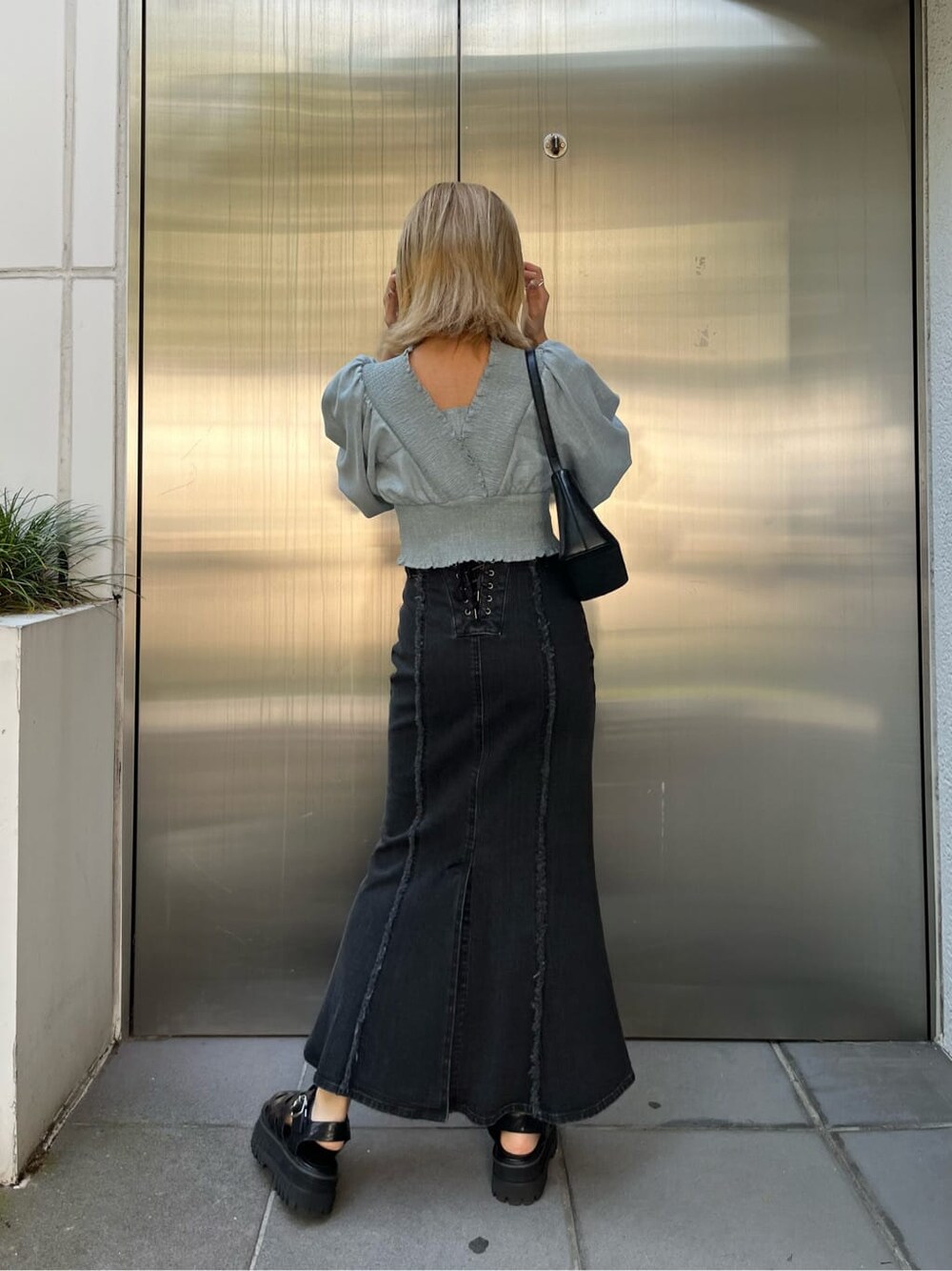 ブラック系のハンドバッグ、ブルー系のスカート、ブルー系のシャツ/ブラウスを着用したレディースの夏コーディネートの5枚目の写真