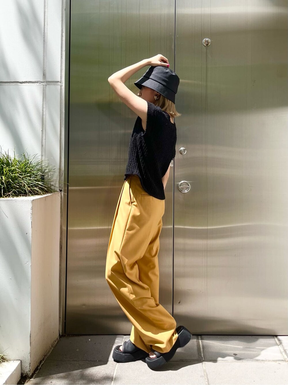 ブラック系のキャミソール、イエロー系のその他パンツ、ブラック系のベストを着用したレディースの春コーディネートの3枚目の写真