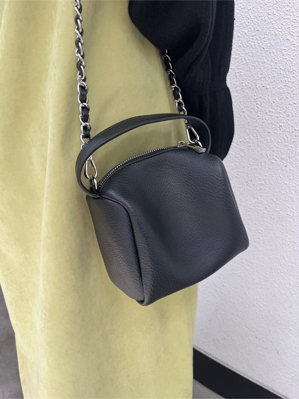 ブラック系のブーツ、ブラック系のニット/セーター、イエロー系のワンピースを着用したレディースの春コーディネートの8枚目の写真