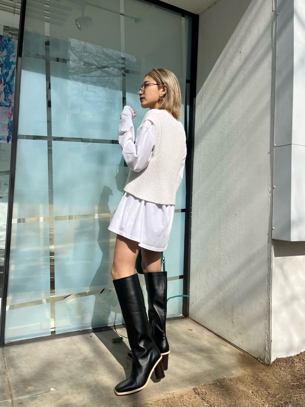 ブラック系のブーツ、ホワイト系のTシャツ/カットソー、ベージュ系のトレンチコートを着用したレディースの春コーディネートの8枚目の写真