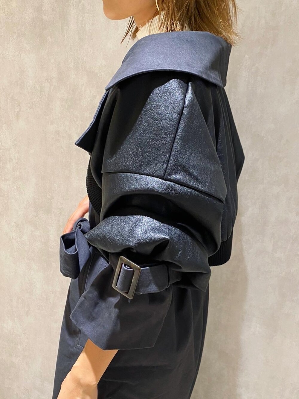 ホワイト系のニット/セーター、グレー系のトレンチコート、ブラック系のブーツを着用したレディースの秋コーディネートの4枚目の写真