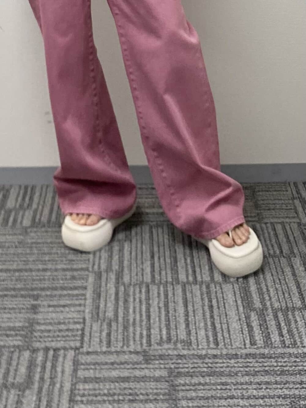 ホワイト系のニット/セーター、ブラック系のタンクトップ、ホワイト系のサンダルを着用したレディースの春コーディネートの6枚目の写真