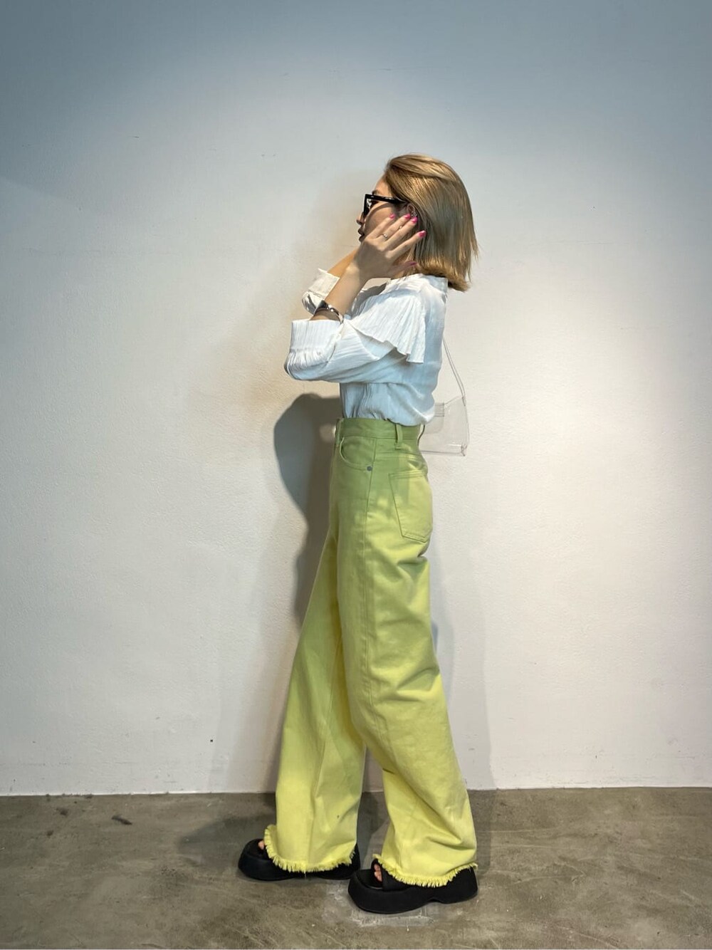 ホワイト系のキャミソール、イエロー系のデニムパンツ、ホワイト系のシャツ/ブラウスを着用したレディースの春コーディネートの2枚目の写真