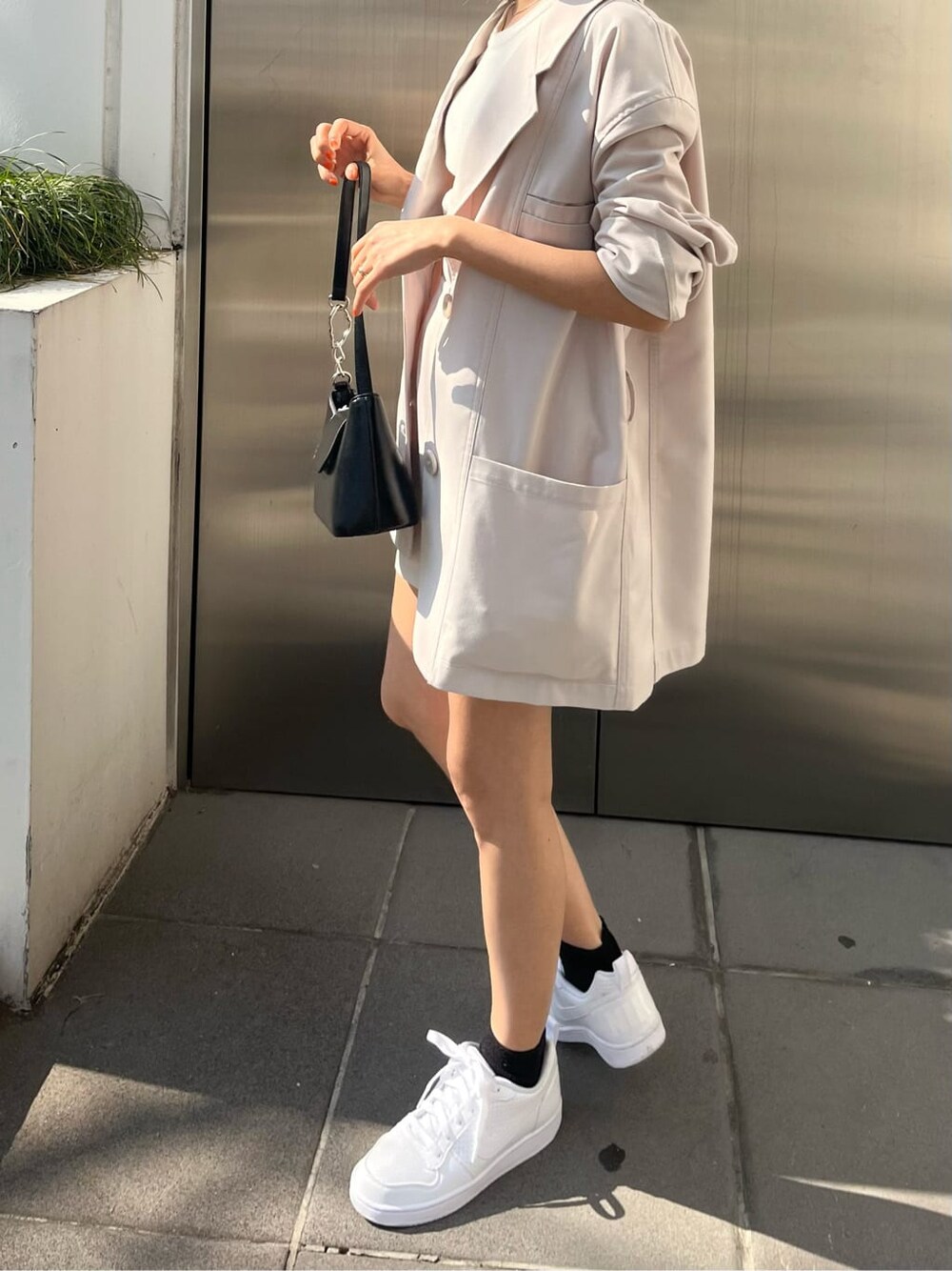 ホワイト系のテーラードジャケット、ホワイト系のスカートを着用したレディースの春コーディネートの4枚目の写真