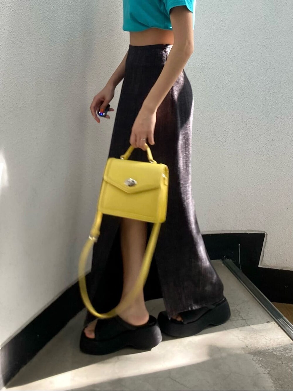 ブラック系のサンダル、ブラック系のスカート、ブルー系のTシャツ/カットソーを着用したレディースの春コーディネートの6枚目の写真