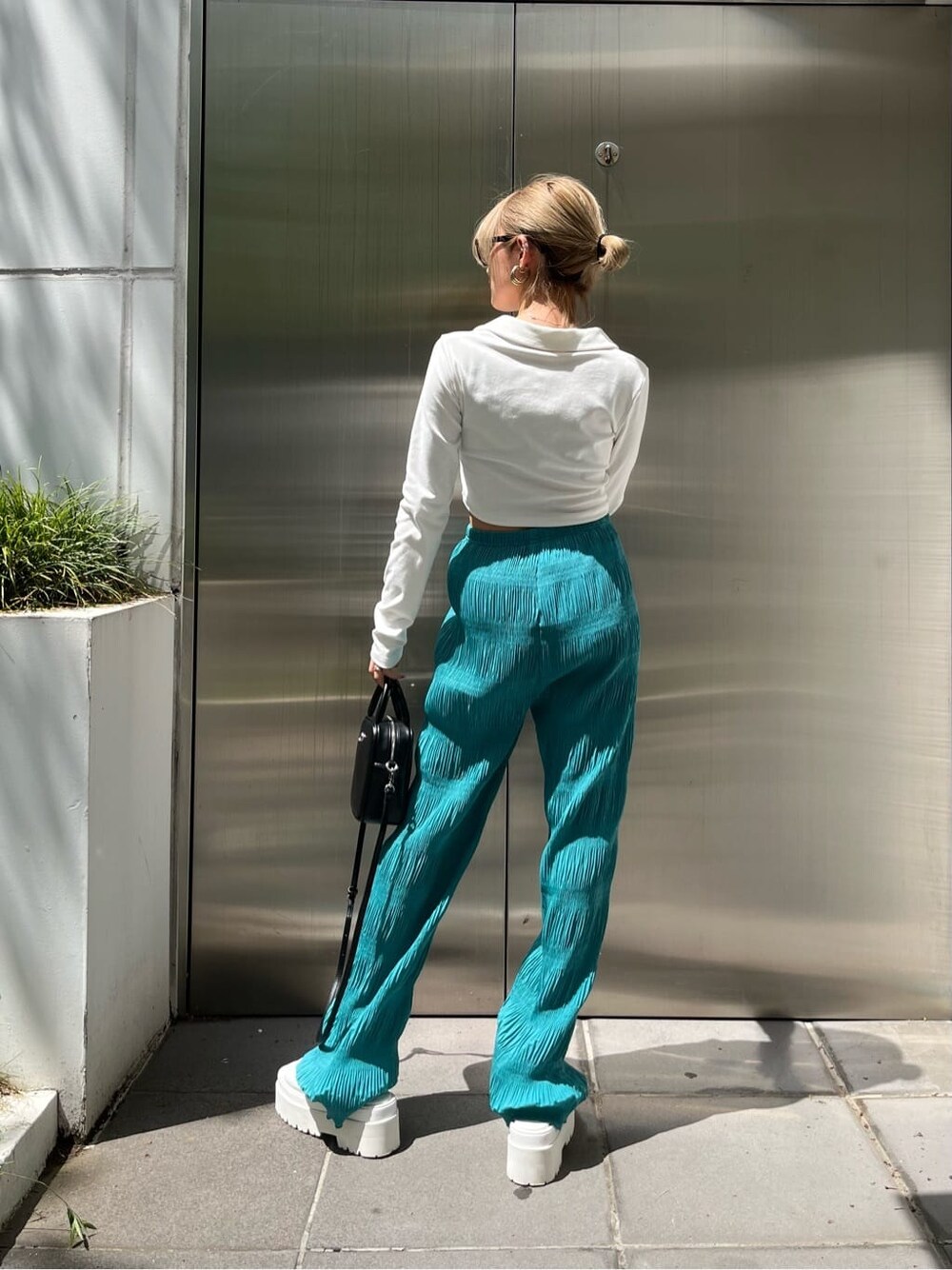 ホワイト系のサンダル、ブラック系のショルダーバッグ、ブルー系のその他パンツを着用したレディースの春コーディネートの4枚目の写真