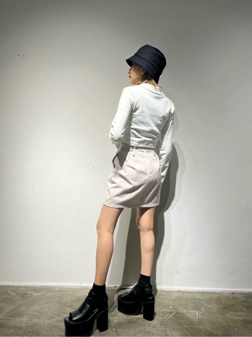 ホワイト系のスカート、イエロー系のTシャツ/カットソー、ブラック系のサンダルを着用したレディースの春コーディネートの3枚目の写真