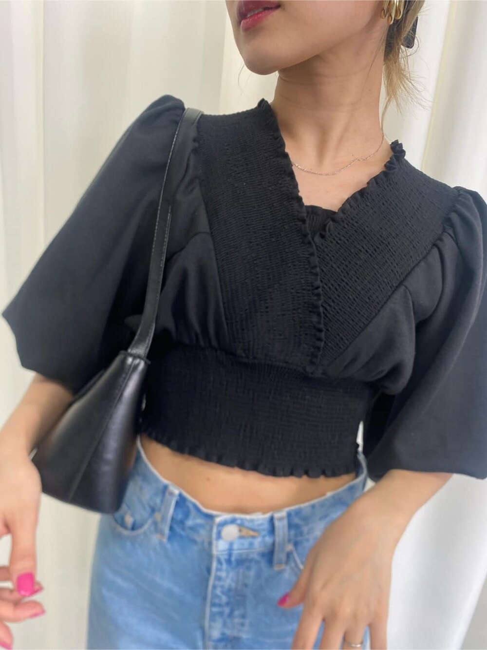 ブラック系のシャツ/ブラウス、ブラック系のハンドバッグ、ブルー系のデニムパンツを着用したレディースの春コーディネートの8枚目の写真