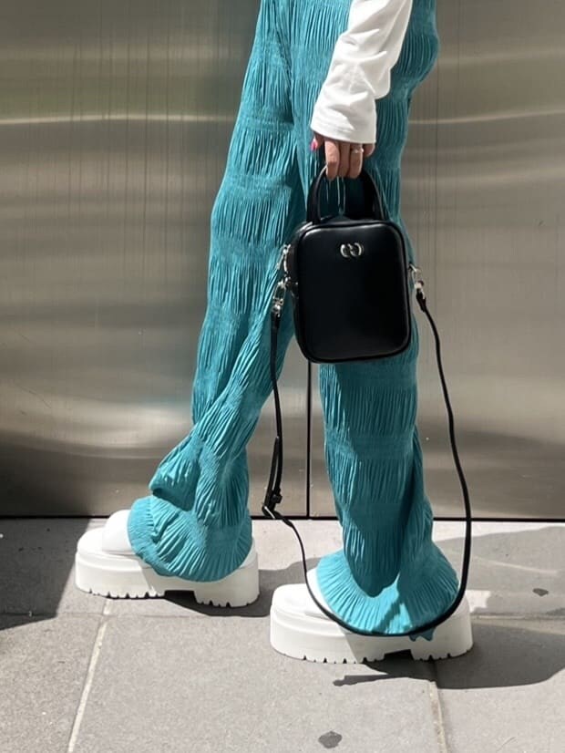 ホワイト系のサンダル、ブラック系のショルダーバッグ、ブルー系のその他パンツを着用したレディースの春コーディネートの7枚目の写真