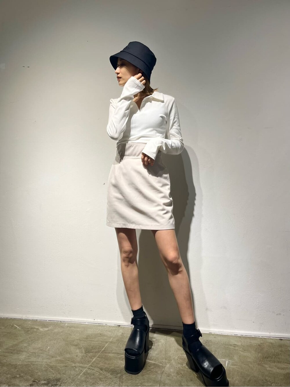 ホワイト系のスカート、イエロー系のTシャツ/カットソー、ブラック系のサンダルを着用したレディースの春コーディネートの2枚目の写真