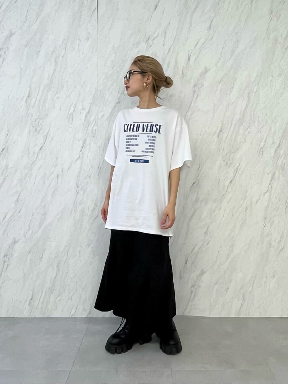 ブラック系のブーツ、ブラック系のスカート、ホワイト系のTシャツ/カットソーを着用したレディースの春コーディネートの5枚目の写真