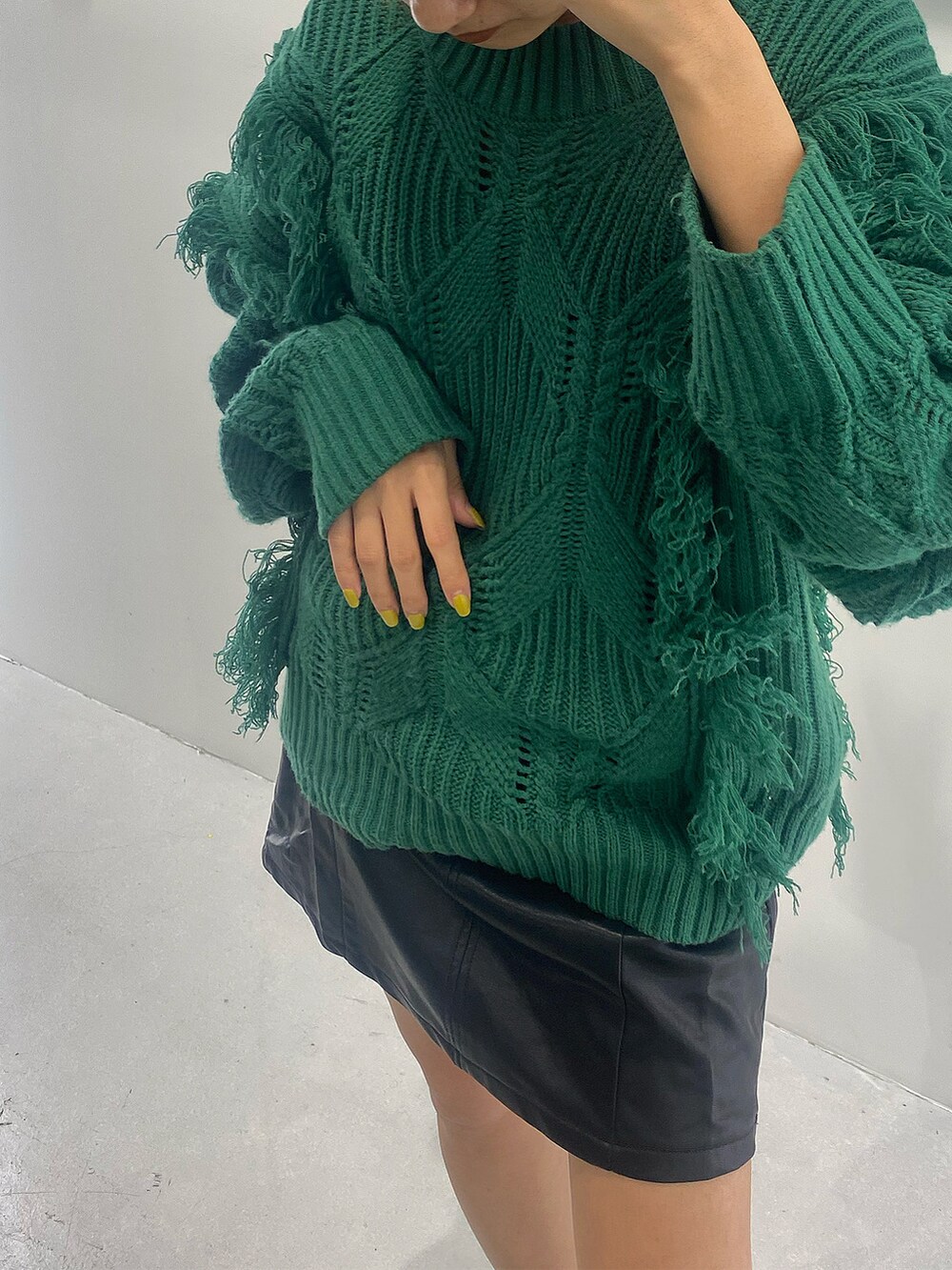 グリーン系のニット/セーター、ブラック系のハンドバッグ、ブラック系のワンピースを着用したレディースの秋コーディネートの5枚目の写真