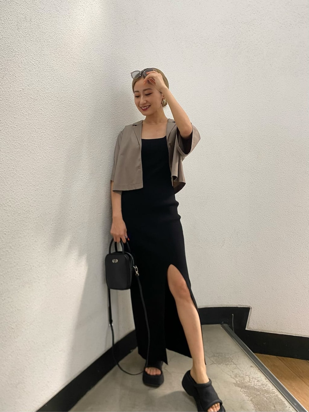 ブラック系のショルダーバッグ、ブラック系のワンピース、ブラック系のサンダルを着用したレディースの春コーディネートの2枚目の写真