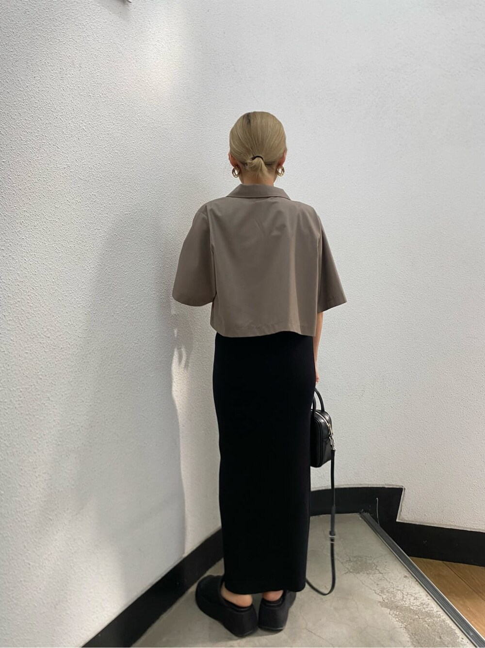 ブラック系のショルダーバッグ、ブラック系のワンピース、ブラック系のサンダルを着用したレディースの春コーディネートの5枚目の写真