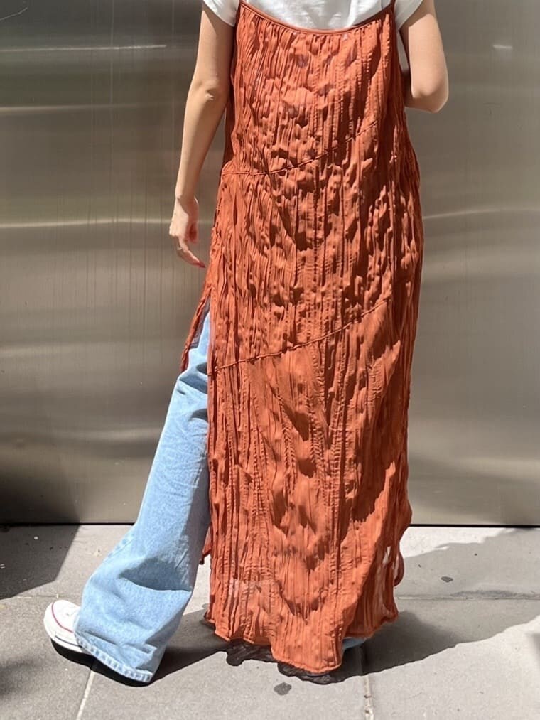 オレンジ系のワンピース、ブルー系のデニムパンツを着用したレディースの春コーディネートの6枚目の写真